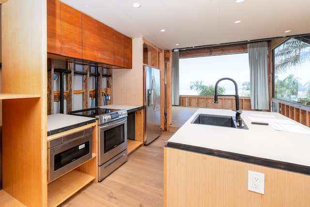 kitchen with light hardwood / wood-style flooring, stainless steel appliances, and sink