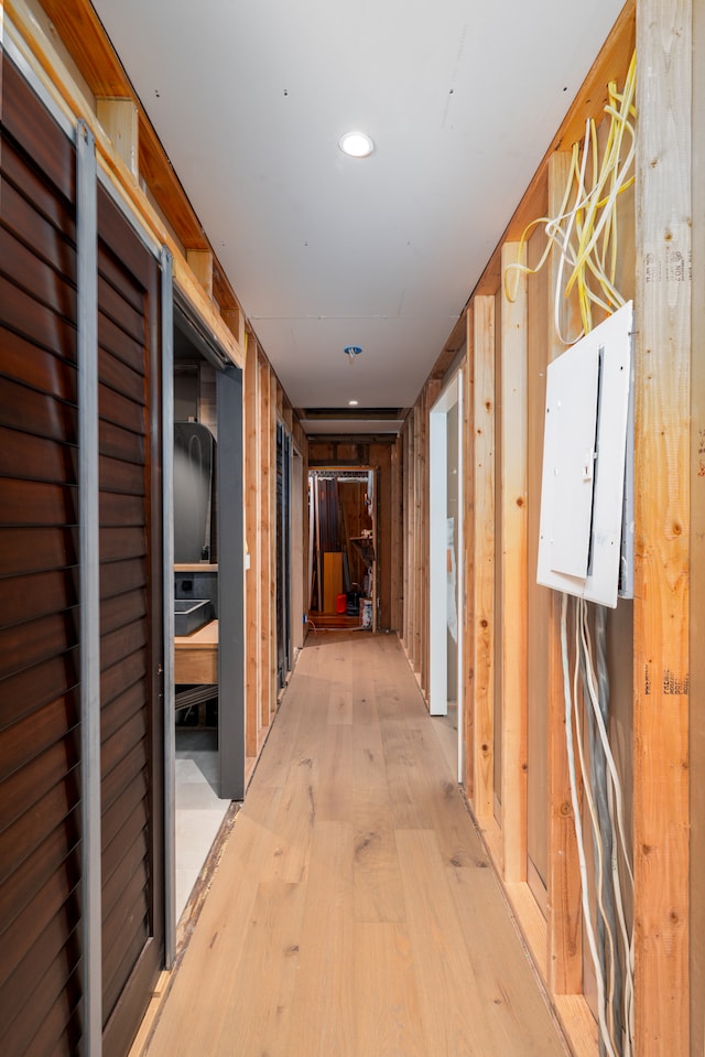 hall featuring wood walls, light hardwood / wood-style flooring, and electric panel