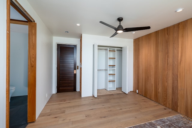 unfurnished bedroom featuring light hardwood / wood-style flooring, ceiling fan, and connected bathroom