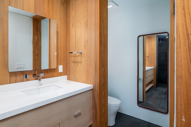 bathroom with tile patterned flooring, vanity, and toilet