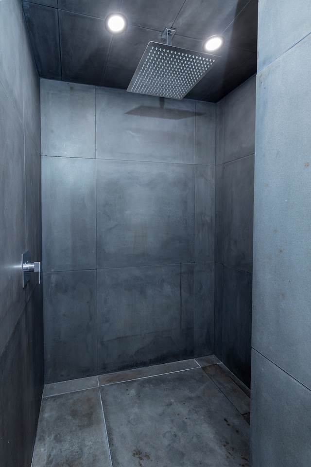 bathroom with a shower and concrete flooring