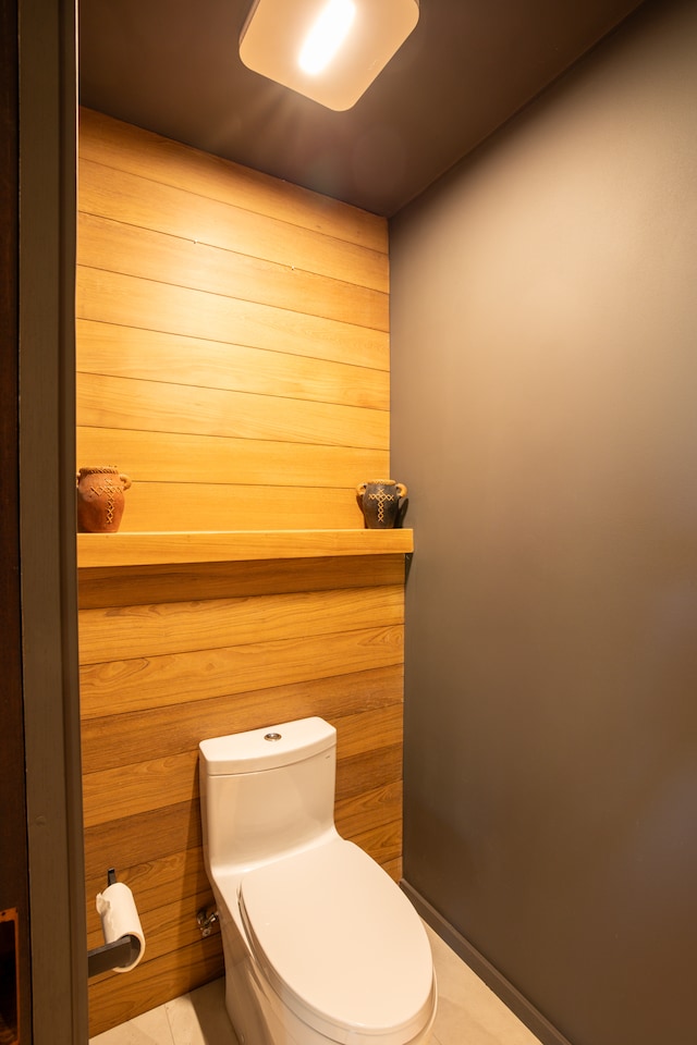 bathroom featuring toilet, wooden walls, and tile patterned floors