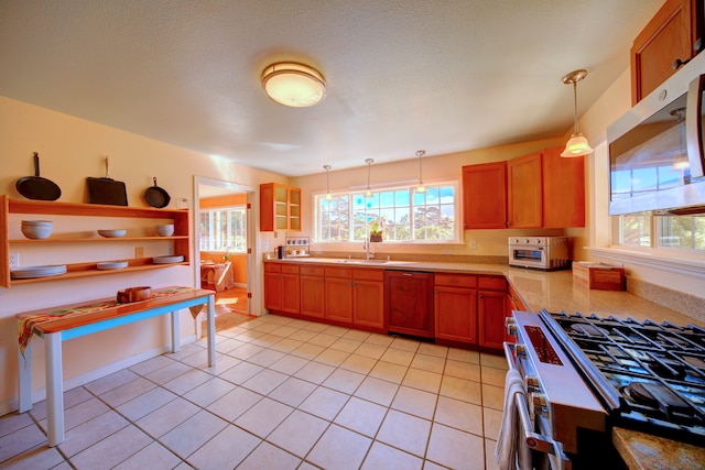 kitchen featuring sink, light tile patterned flooring, a textured ceiling, hanging light fixtures, and stainless steel appliances