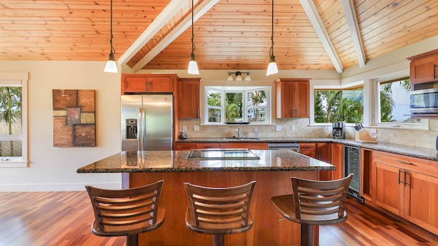 kitchen with a center island, beverage cooler, stainless steel appliances, and vaulted ceiling with beams