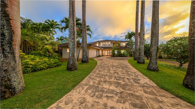 view of front of home with a garage and a lawn