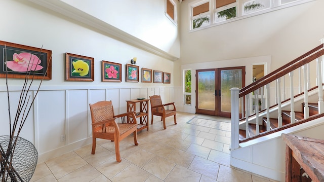 tiled foyer entrance featuring french doors, a wealth of natural light, and a high ceiling