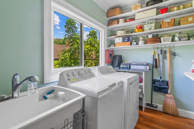 clothes washing area featuring independent washer and dryer, sink, and hardwood / wood-style floors