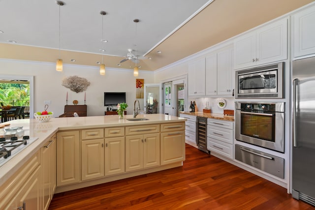 kitchen with built in appliances, wine cooler, decorative light fixtures, crown molding, and dark wood-type flooring