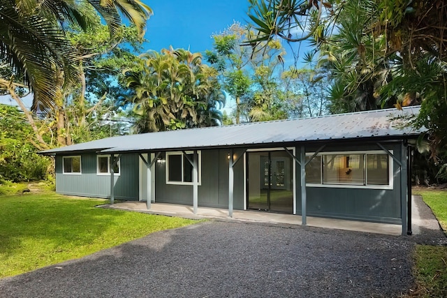 back of property with a lawn and a patio