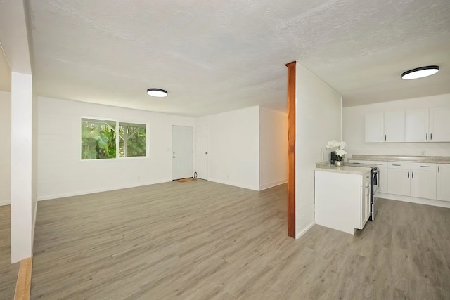 interior space with light wood-type flooring and a textured ceiling