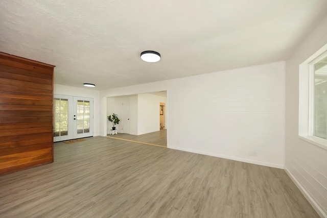 spare room featuring plenty of natural light, hardwood / wood-style flooring, and french doors