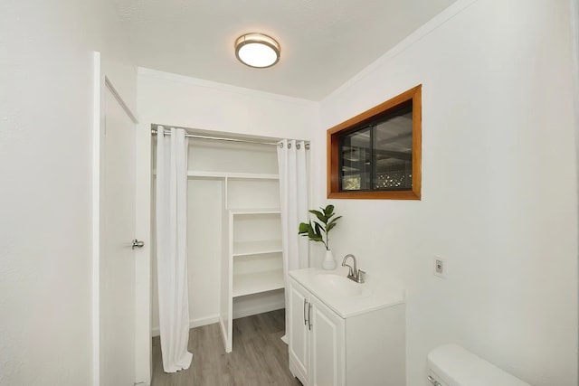 bathroom with ornamental molding, vanity, toilet, and hardwood / wood-style floors