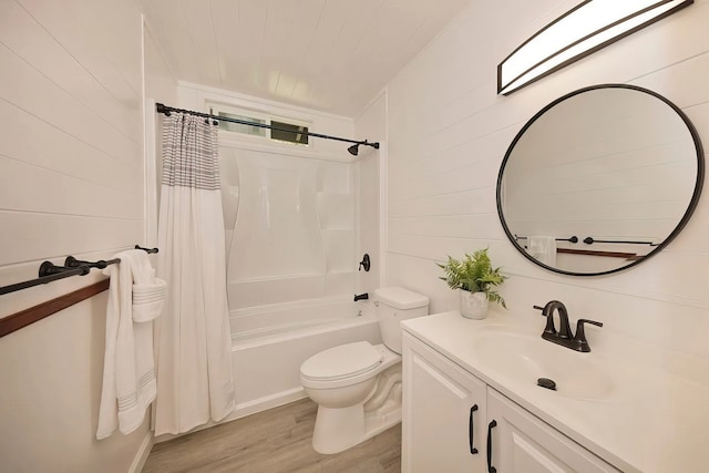 full bathroom with hardwood / wood-style floors, toilet, shower / tub combo, wood walls, and vanity