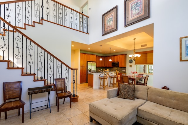 tiled living room featuring an inviting chandelier and a high ceiling