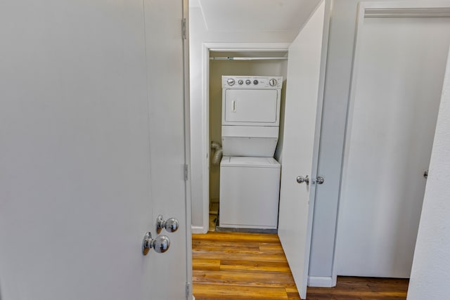 laundry area featuring light wood-type flooring and stacked washer / drying machine