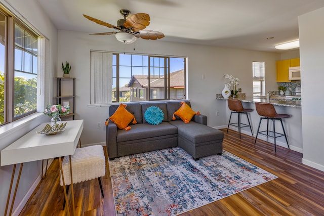 living room with a healthy amount of sunlight, ceiling fan, and dark hardwood / wood-style flooring