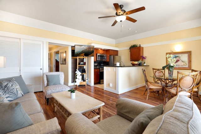 living room featuring ceiling fan and hardwood / wood-style flooring