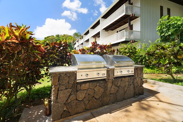 view of patio / terrace featuring exterior kitchen, area for grilling, and a balcony