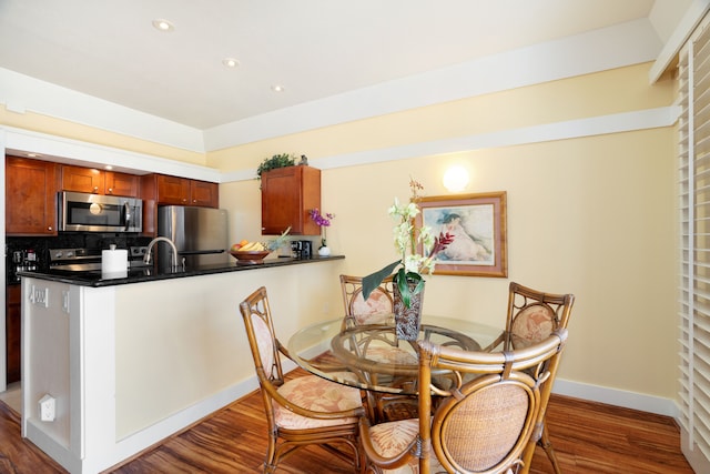 dining room with sink and dark hardwood / wood-style flooring