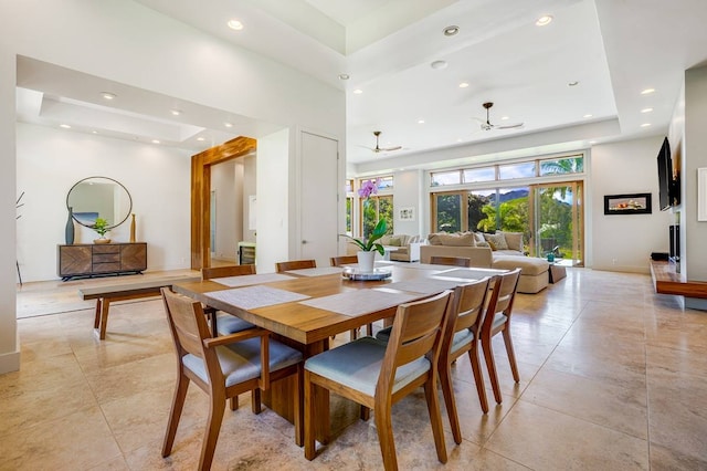 dining room featuring ceiling fan, light tile patterned floors, and a raised ceiling