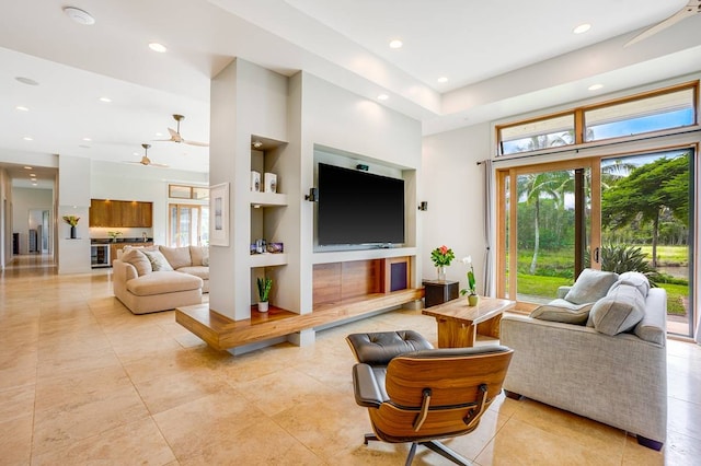 living room with built in features, light tile patterned floors, and ceiling fan