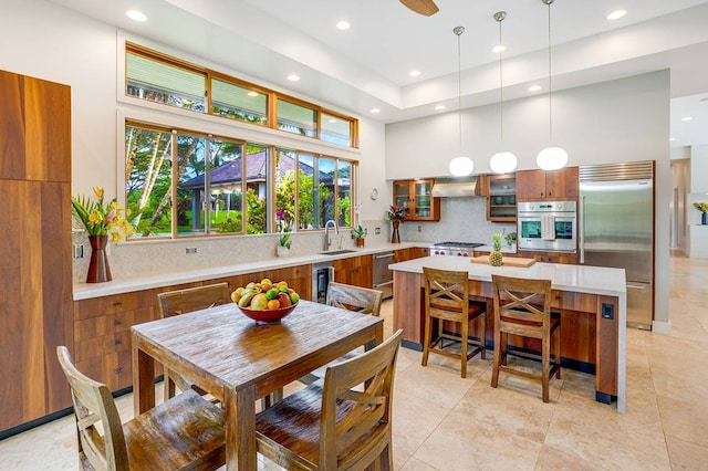 kitchen with hanging light fixtures, light tile patterned floors, a kitchen island, stainless steel appliances, and decorative backsplash