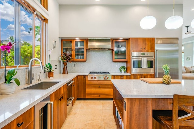 kitchen with stainless steel appliances, beverage cooler, wall chimney range hood, plenty of natural light, and decorative light fixtures