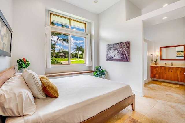 tiled bedroom with a towering ceiling, connected bathroom, and sink