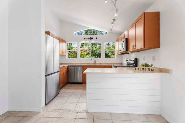 kitchen featuring kitchen peninsula, stainless steel appliances, sink, vaulted ceiling, and light tile patterned flooring