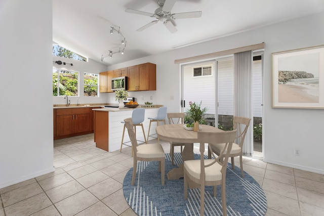 dining area featuring sink, vaulted ceiling, light tile patterned floors, and ceiling fan