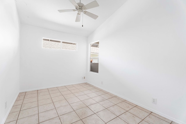 empty room with lofted ceiling, light tile patterned flooring, and ceiling fan