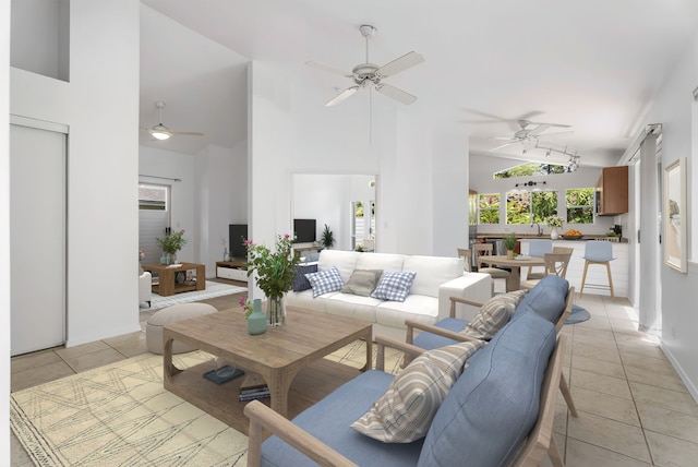 living room with high vaulted ceiling and light tile patterned floors