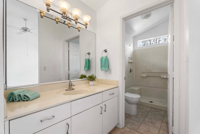 bathroom featuring lofted ceiling, toilet, tiled shower, vanity, and tile patterned flooring