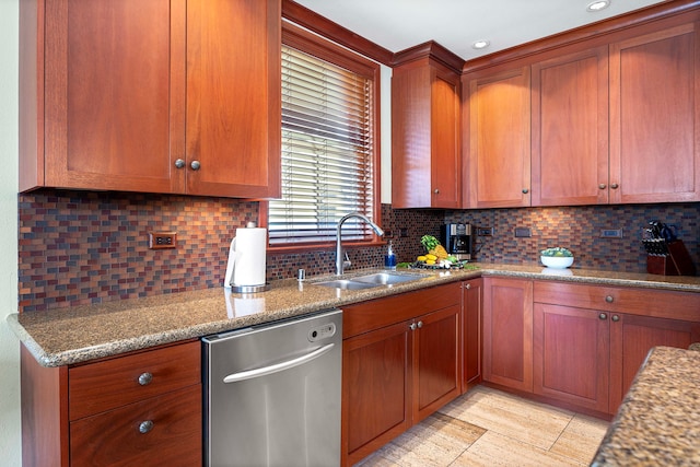 kitchen with light stone counters, brown cabinets, decorative backsplash, stainless steel dishwasher, and a sink