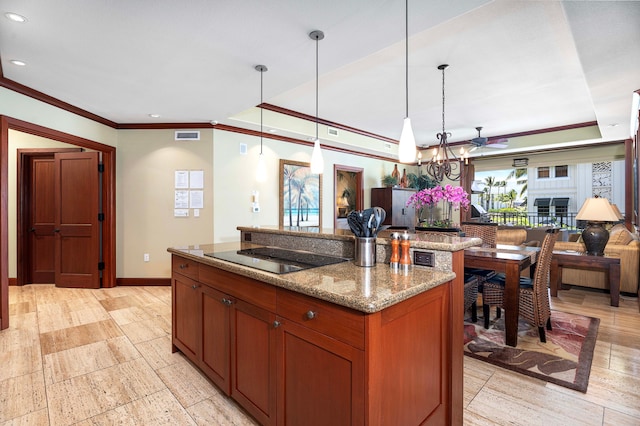 kitchen featuring a healthy amount of sunlight, pendant lighting, black electric stovetop, and ceiling fan