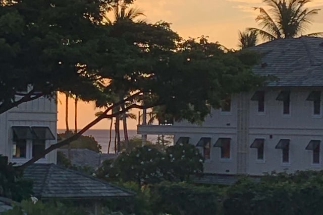 property exterior at dusk featuring a water view