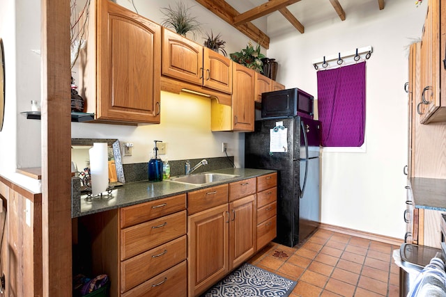 kitchen featuring black appliances, light tile patterned floors, sink, and beam ceiling