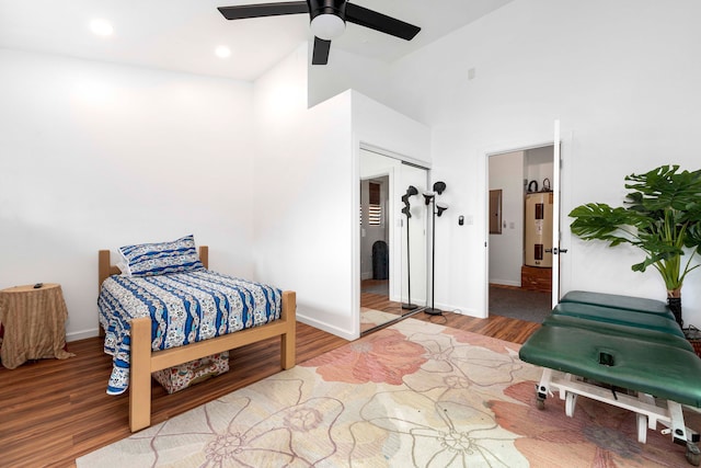 bedroom featuring light hardwood / wood-style flooring, ceiling fan, a closet, and high vaulted ceiling