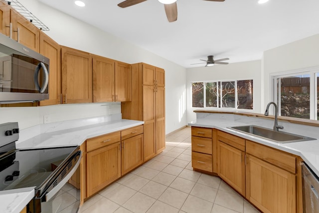 kitchen with a sink, light tile patterned floors, appliances with stainless steel finishes, and ceiling fan