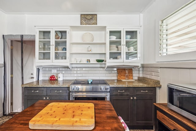 kitchen featuring decorative backsplash, dark stone countertops, white cabinetry, and appliances with stainless steel finishes