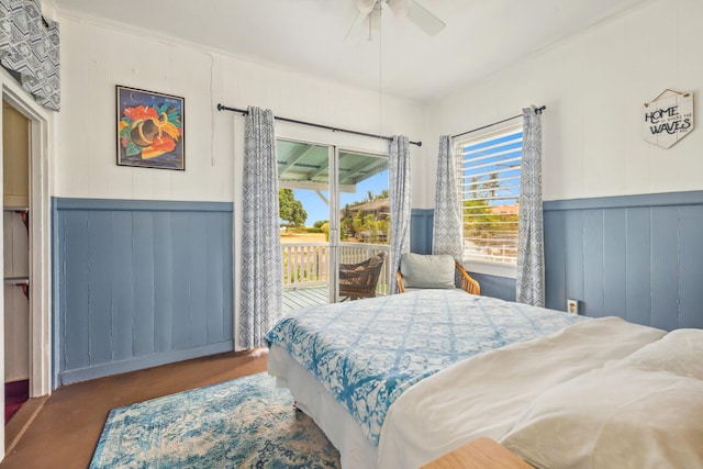 bedroom with wood walls, ceiling fan, access to exterior, and crown molding