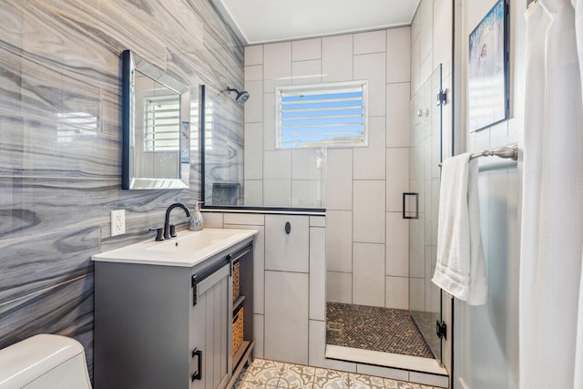 bathroom with tile walls, a tile shower, vanity, and toilet