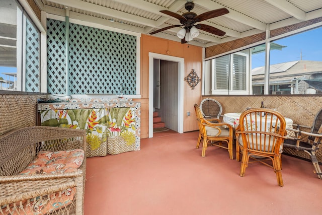 sunroom / solarium with ceiling fan and beamed ceiling