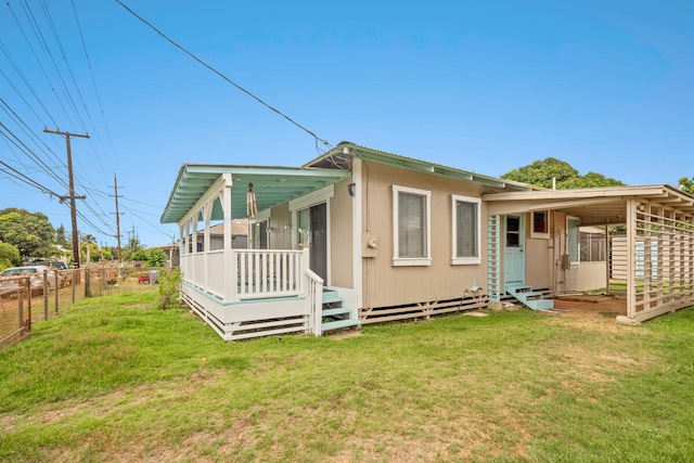 rear view of property with a sunroom and a lawn