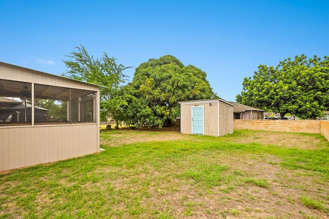 view of yard featuring a storage unit and a sunroom