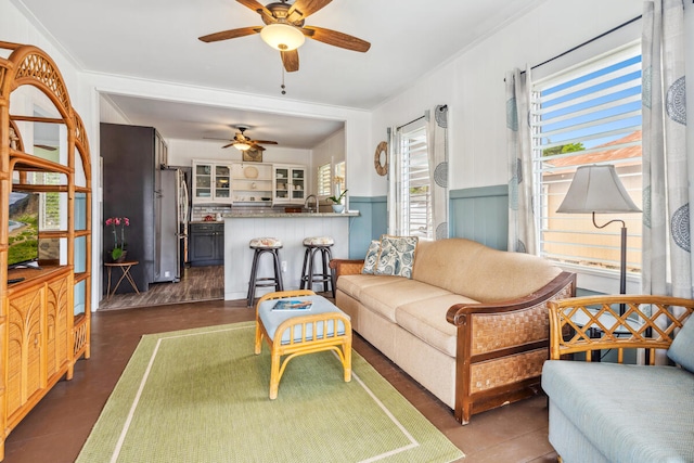 living room with ceiling fan and crown molding