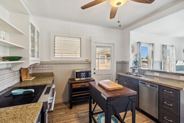 kitchen with appliances with stainless steel finishes, tasteful backsplash, ceiling fan, and white cabinets