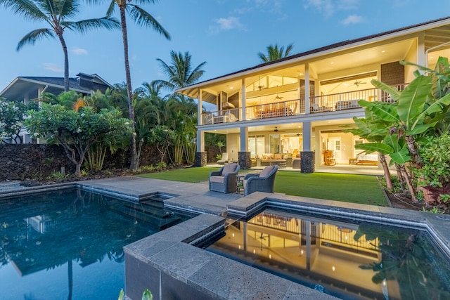 pool at dusk featuring a lawn and a patio