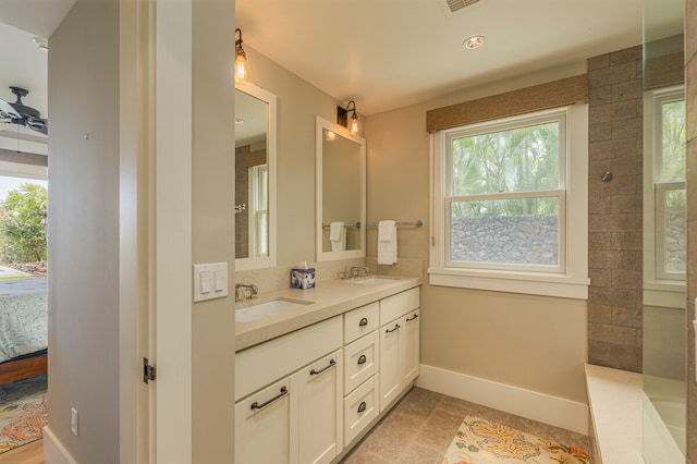 bathroom featuring tile patterned floors, tiled shower, plenty of natural light, and vanity