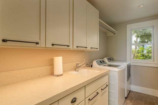 washroom featuring separate washer and dryer, cabinets, and sink